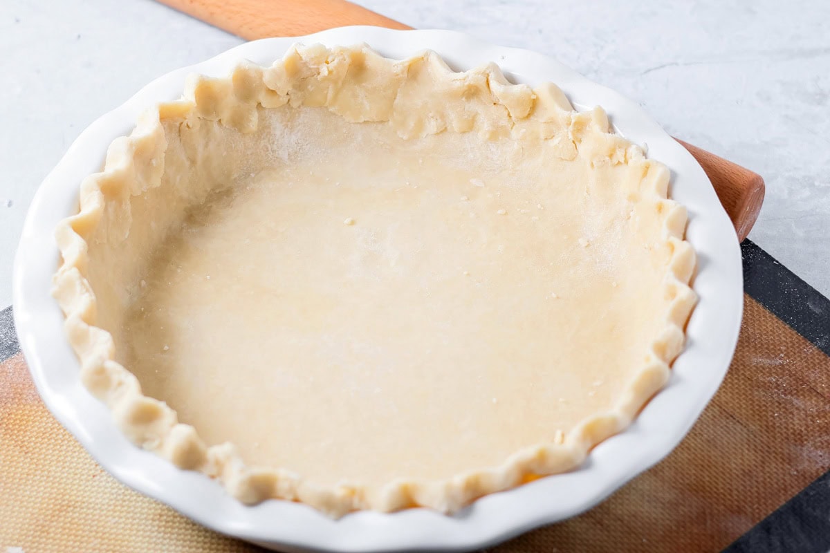 Sour cream apple pie elevates the classic with a rich, tangy, and creamy custard and a buttery crumb topping! Shaped pie crust in a pie pan.