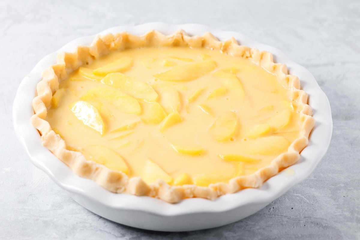 Sour cream apple pie elevates the classic with a rich, tangy, and creamy custard and a buttery crumb topping! Custard and apples in a pie crust.