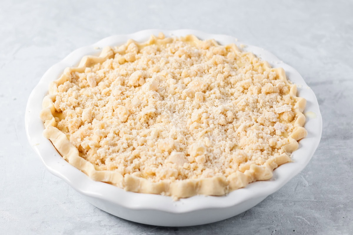 Sour cream apple pie elevates the classic with a rich, tangy, and creamy custard and a buttery crumb topping! Crumb topping on a pie crust.
