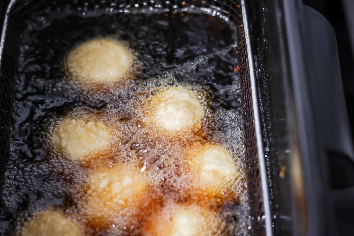 Bonuts being fried in oil.