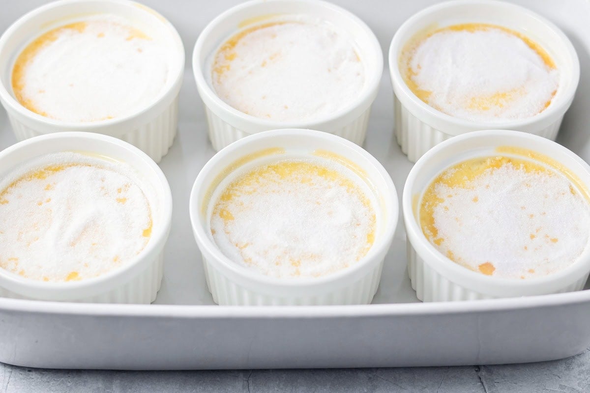 6 baked creme brulees topped with granulated sugar.