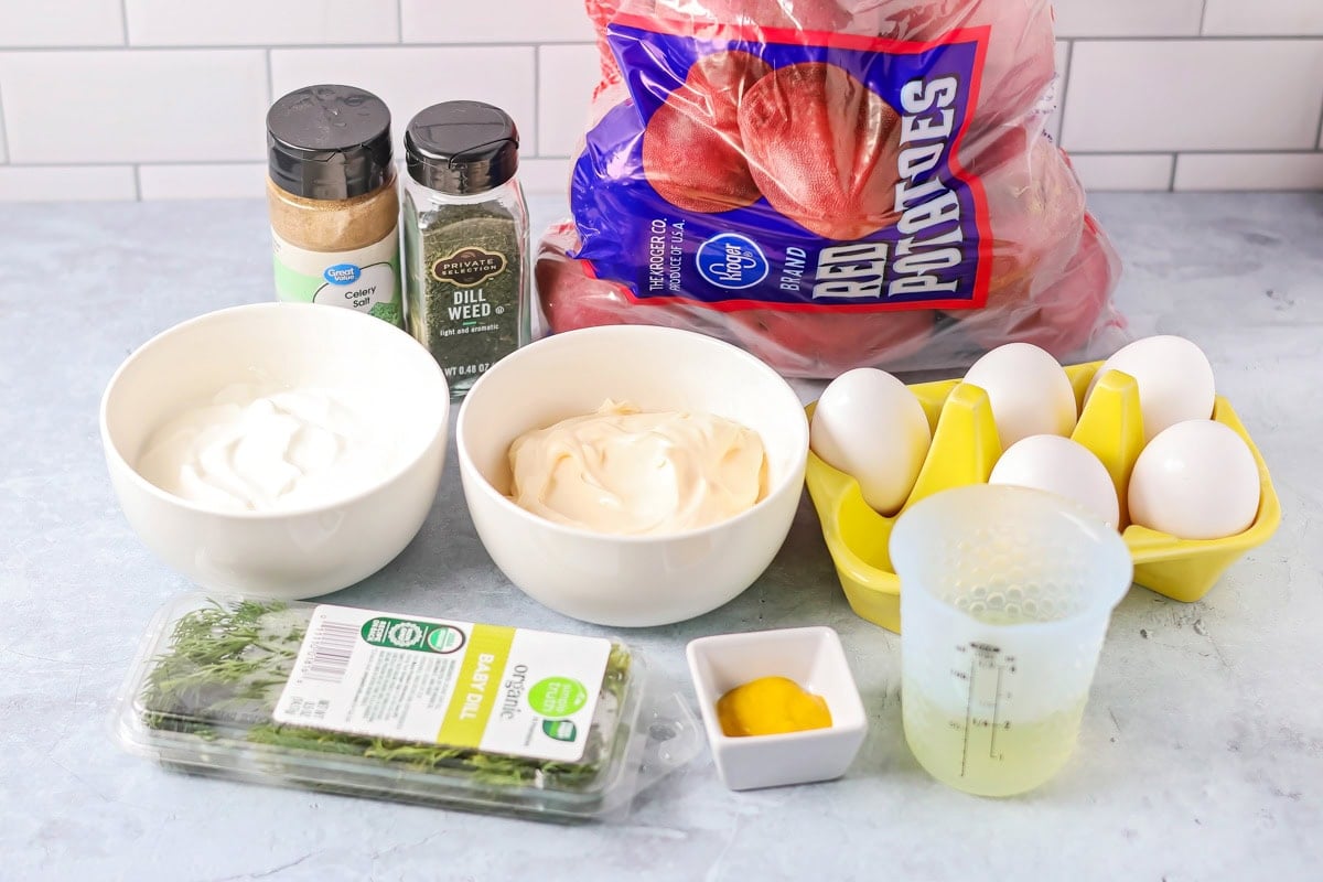 Ingredients to make dill potato salad on a kitchen counter.