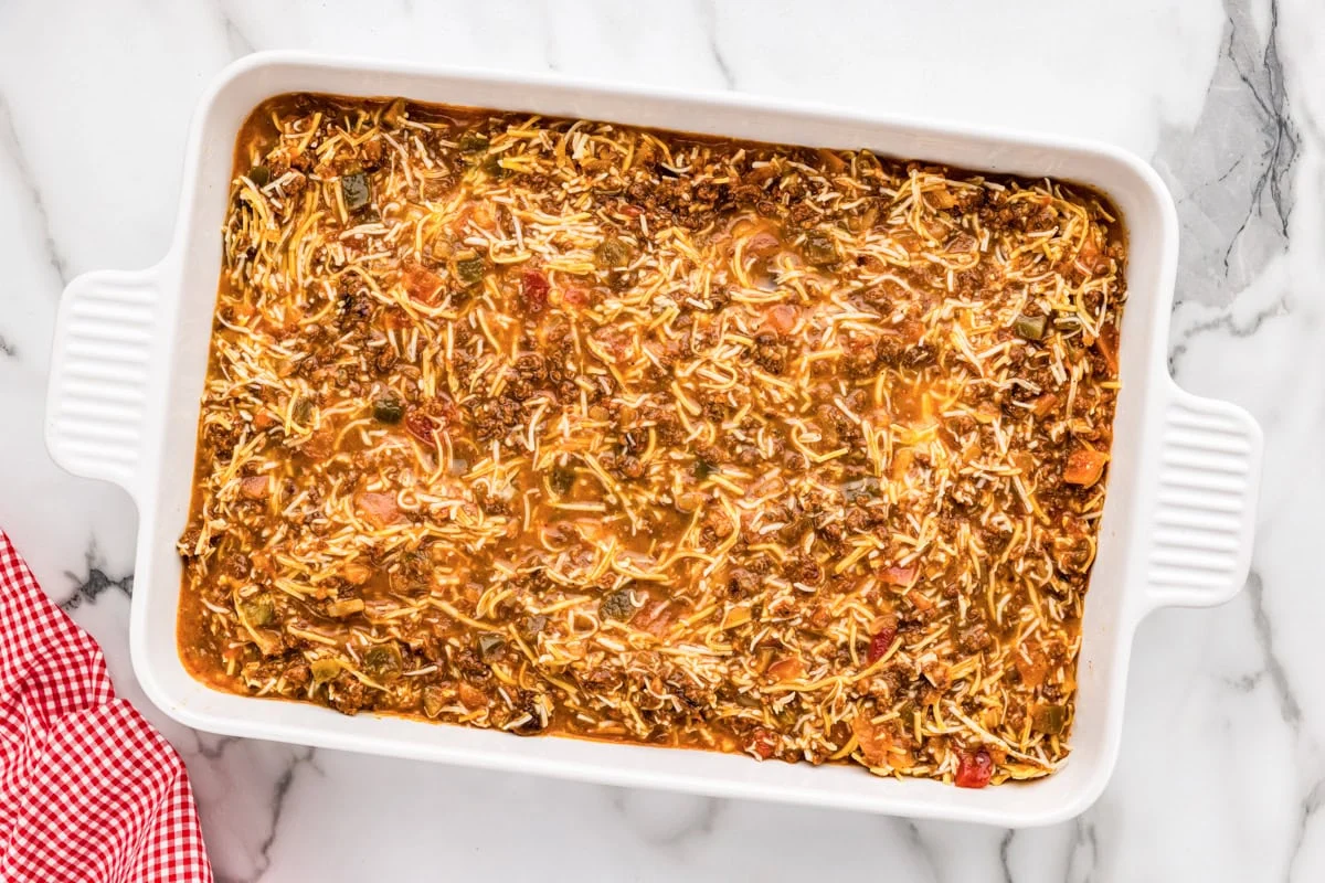 The ingredients for Mexican breakfast casserole recipe in a baking dish ready to be put in the oven. 