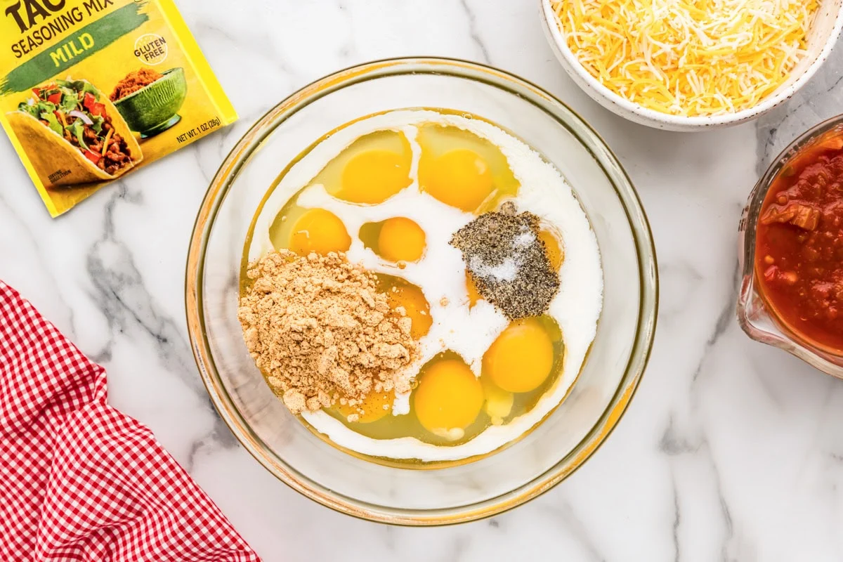 Unmixed savory custard ingredients in a glass mixing bowl. 