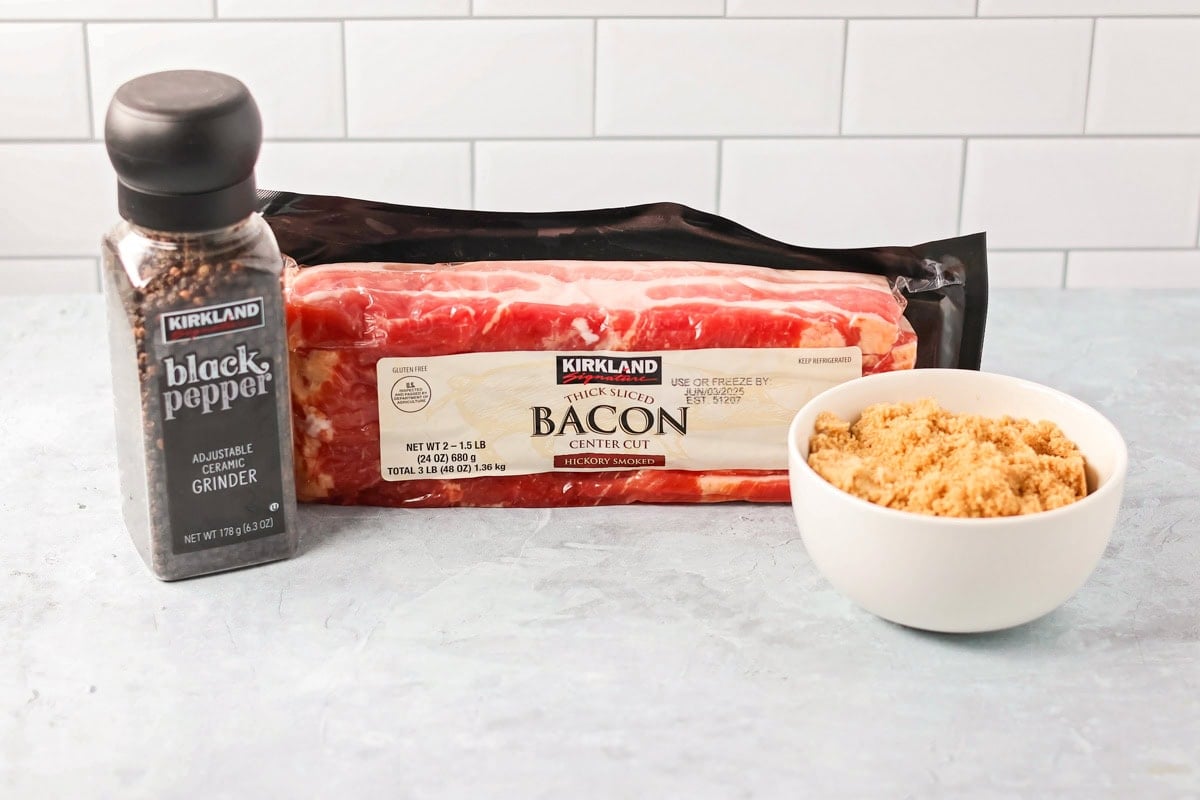 This 3-ingredient candied bacon is the perfect balance of sweet and salty and the ultimate upgrade to any gathering. Ingredients to make candied bacon on a kitchen counter.