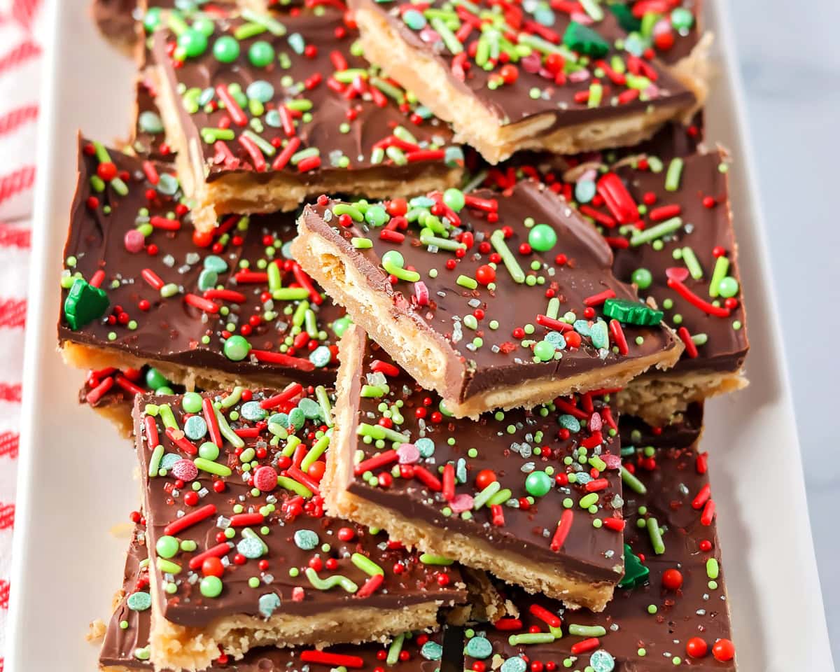 Homemade Christmas crack recipe cut and topped of each other on serving plate.