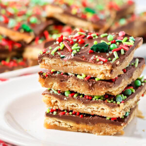 Christmas crack recipe stacked on top of each other on white plate.