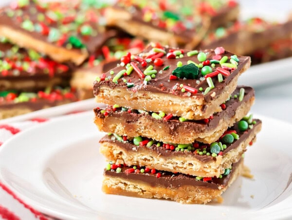 Christmas crack recipe stacked on top of each other on white plate.