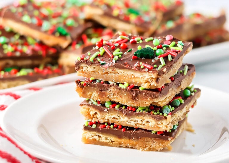 Christmas crack recipe stacked on top of each other on white plate.