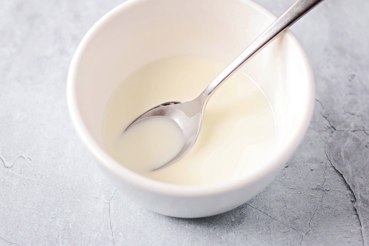A corn starch slurry in a white bowl.