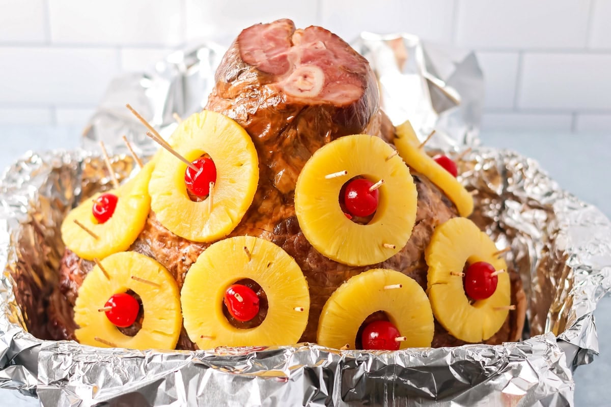 Stud the pineapple rings with a cherry in the center all over the ham to look like Christmas ornaments.