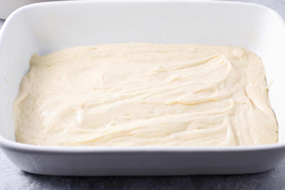 Cinnamon roll poke cake batter in a white baking dish.
