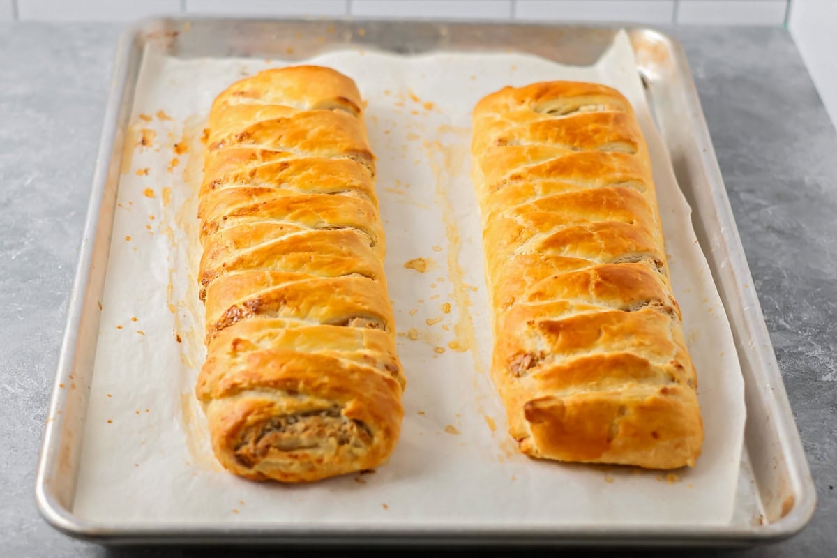 A pair of fully baked Danish kringles on a baking pan.