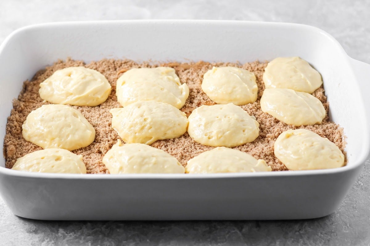 Dollops of batter on top of a layer of cinnamon brown sugar.