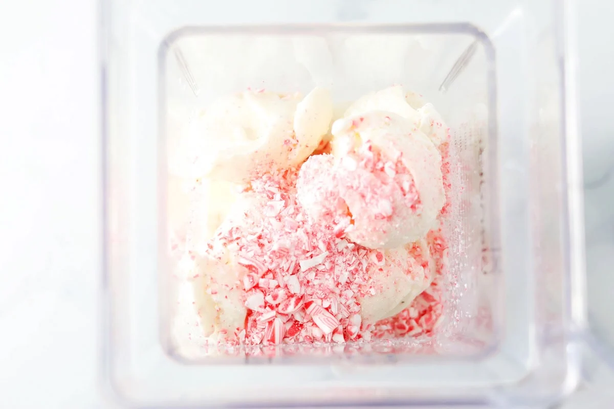 Celebrate the season with this festive peppermint milkshake - it's ready in minutes for a perfect holiday treat! Ingredients for peppermint milkshake in a blender waiting to be mixed.