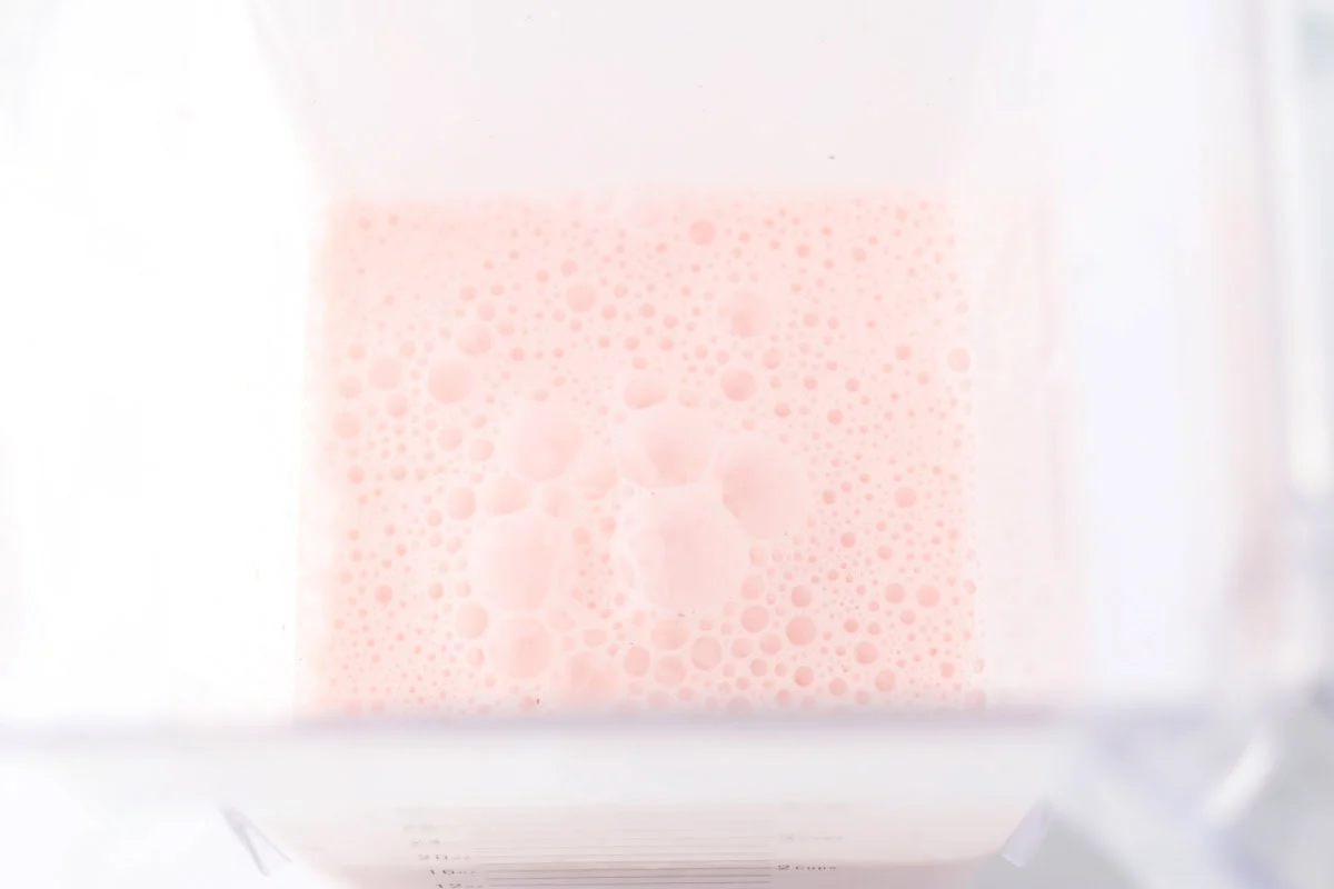 Celebrate the season with this festive peppermint milkshake - it's ready in minutes for a perfect holiday treat! Blended peppermint milkshake in a blender.