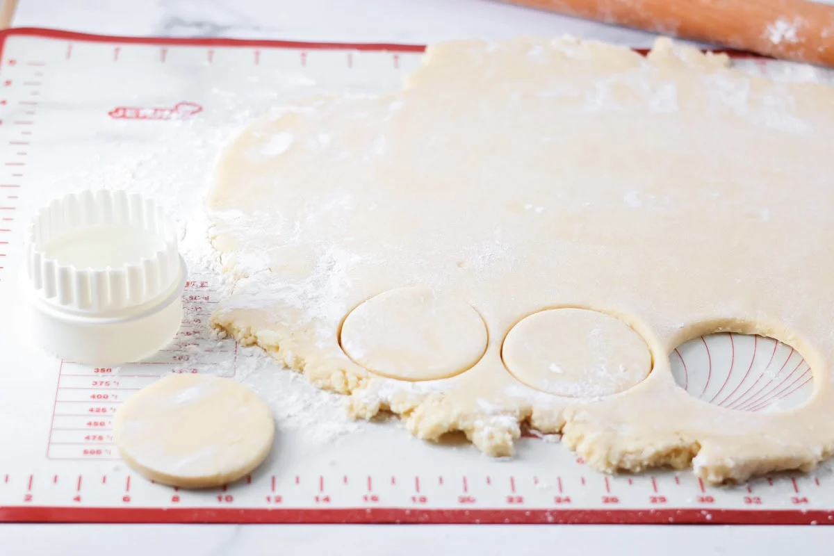 Using a cookie cutter to stamp out cookies from the rolled out dough.