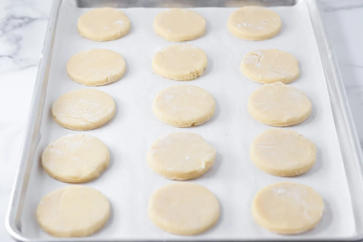 Circle cookie dough cut out on a baking sheet.