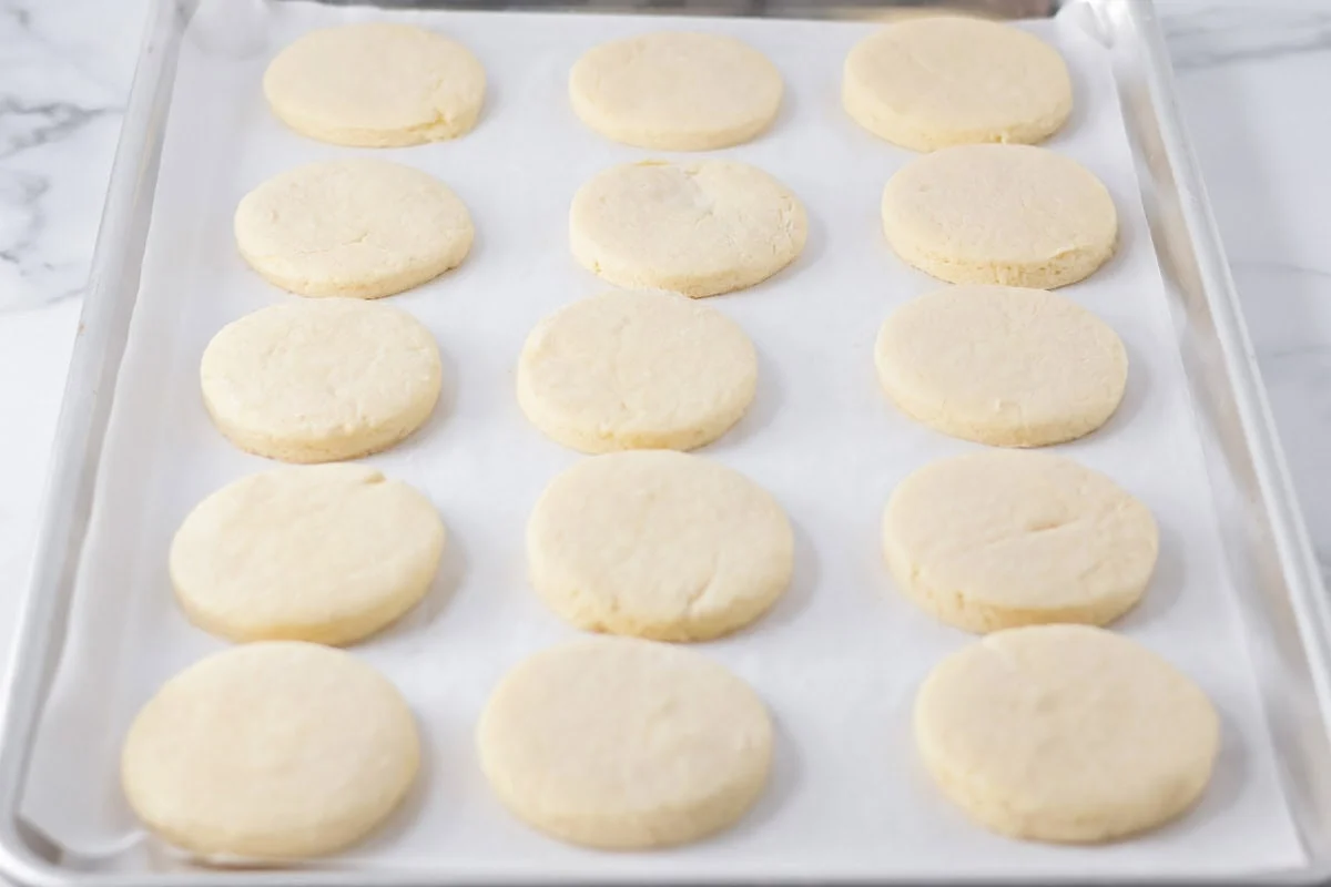 Baked sugar cookies on a baking sheet.