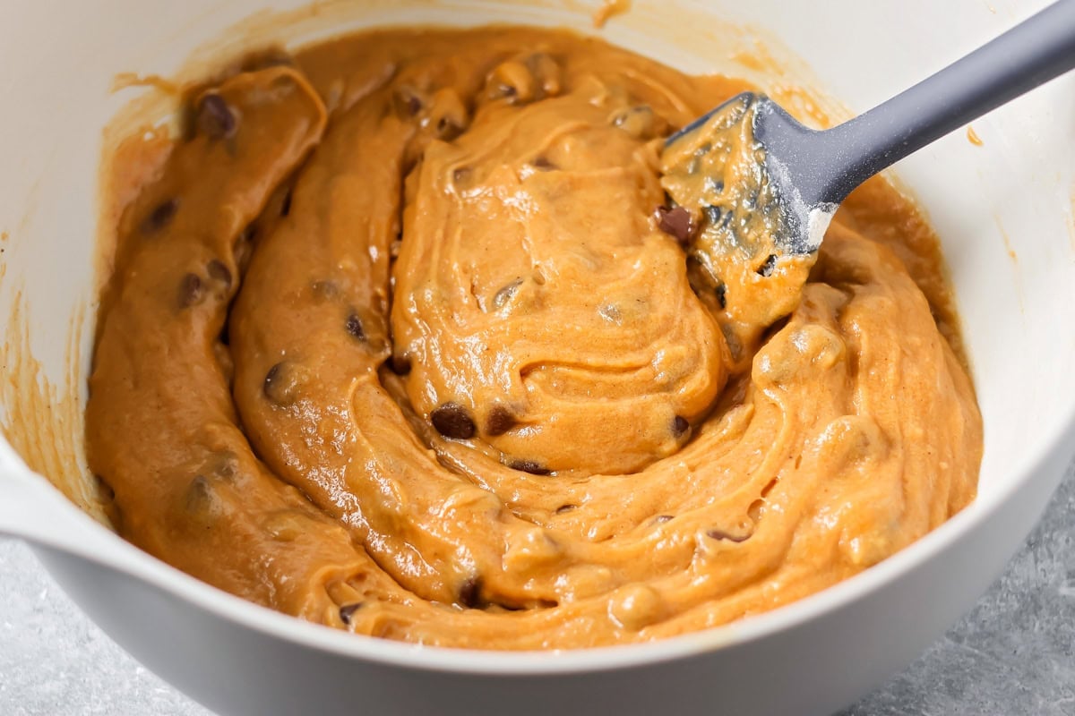 Pumpkin bar batter in a white bowl with chocolate chips folded in. 