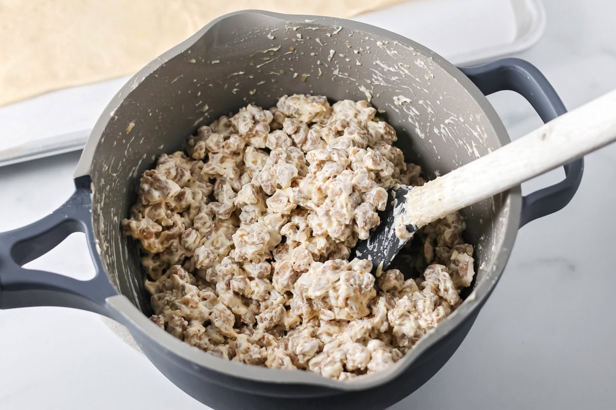 Sausage and cream cheese mixture mixed together in pot.