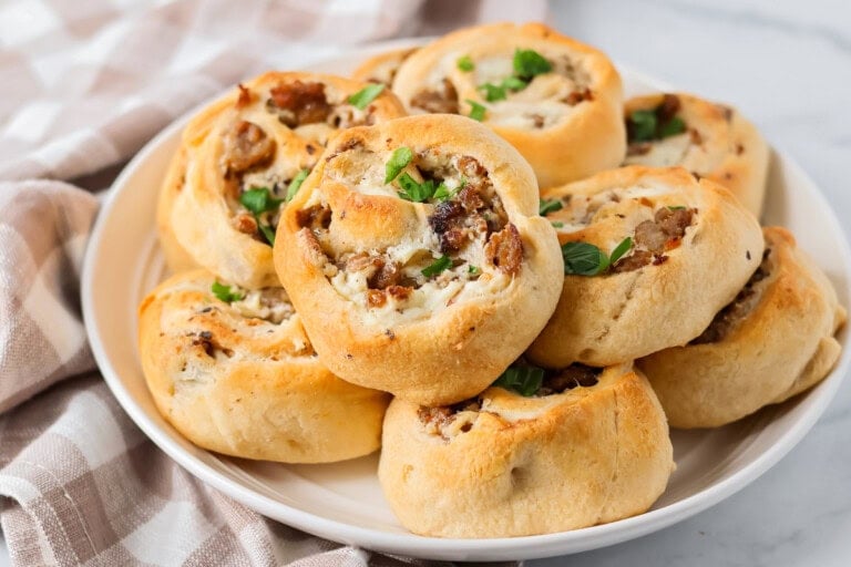 Homemade Sausage pinwheels recipe stacked on top of each other on plate.