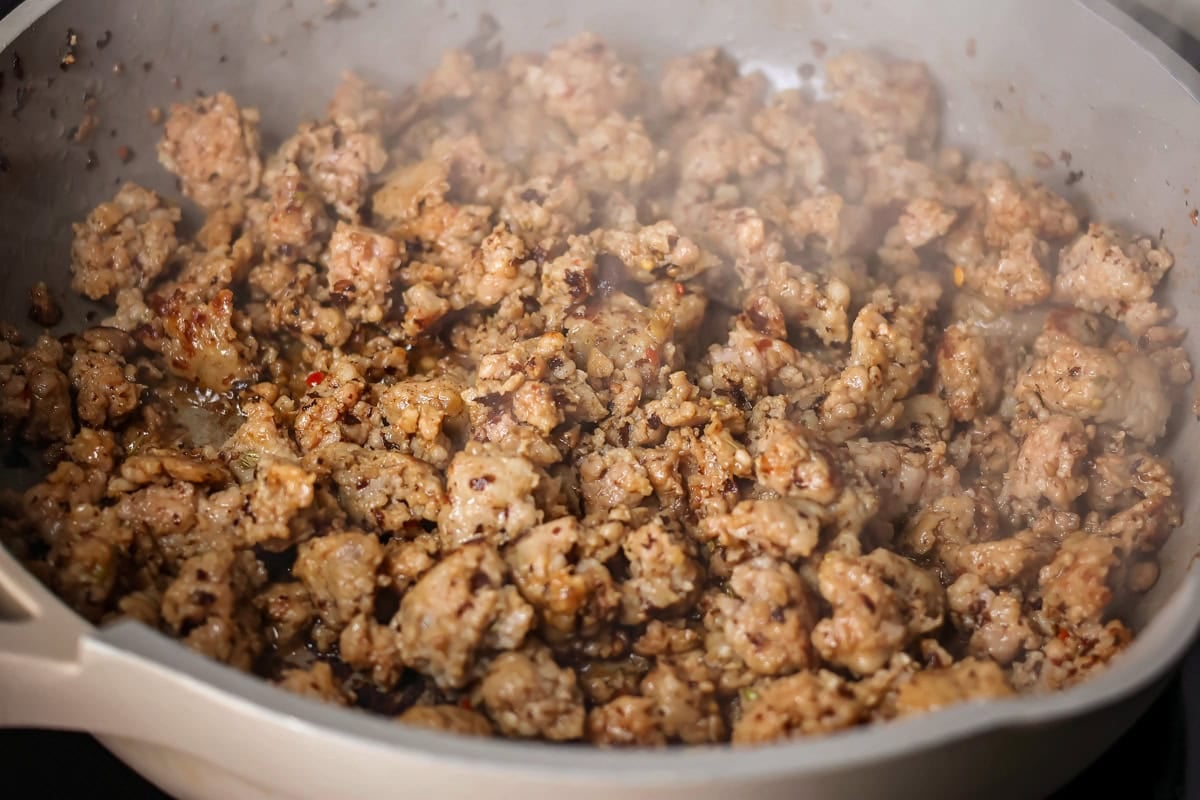 Filled with sausage crumbles and cream cheese, these sausage pinwheels are the ultimate savory snack or party appetizer! Browned sausage in a skillet.