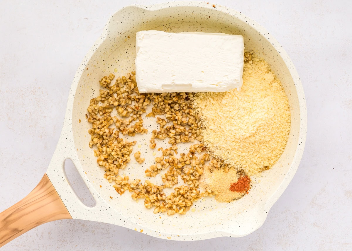 These cream cheese stuffed mushrooms are an easy, savory appetizer thatโs always the first to disappear at any party! Filling ingredients in a skillet.