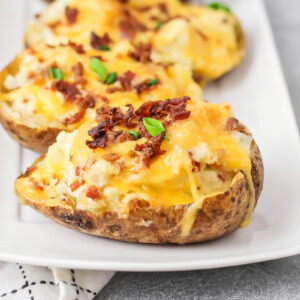 Twice baked potatoes on white serving dish.