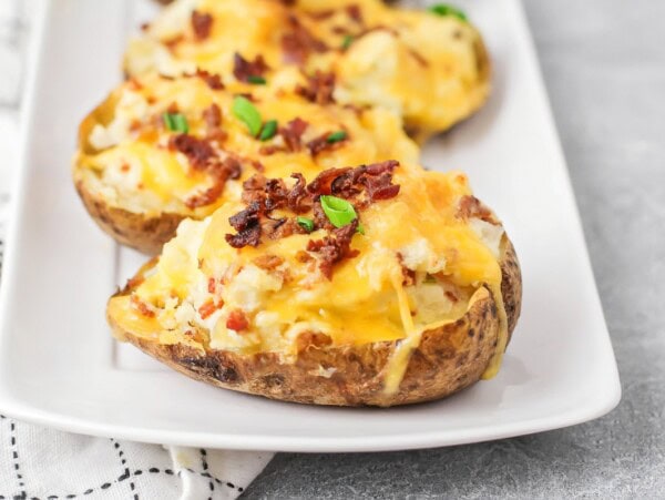 Twice baked potatoes on white serving dish.