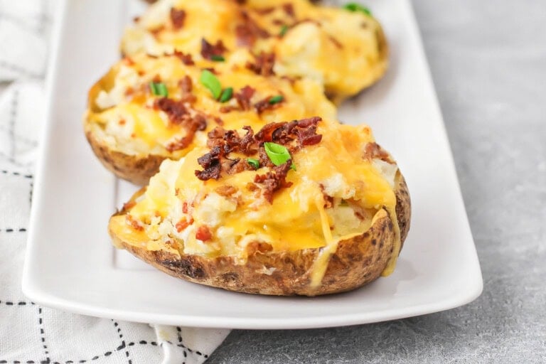 Twice baked potatoes on white serving dish.