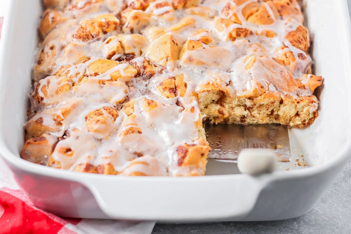 Warm, gooey, and easy to make, this cinnamon roll casserole turns refrigerated rolls into a cozy breakfast everyone will love. Baked cinnamon Roll casserole with a slice missing.