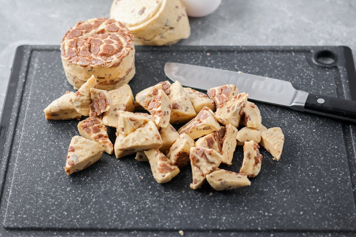 Warm, gooey, and easy to make, this cinnamon roll casserole turns refrigerated rolls into a cozy breakfast everyone will love. Cutting refrigerated cinnamon roll dough into cubes on a cutting board.