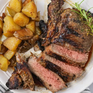 Sliced up Italian rib eye served alongside roasted potatoes.