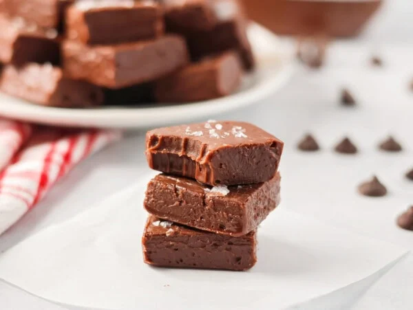 Pieces of homemade nutella fudge stacked on a white plate.