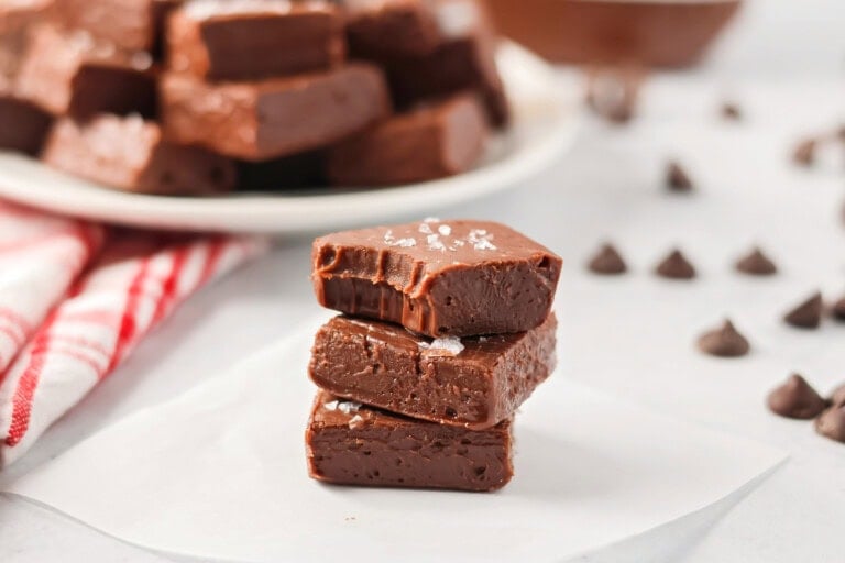 Pieces of homemade nutella fudge stacked on a white plate.