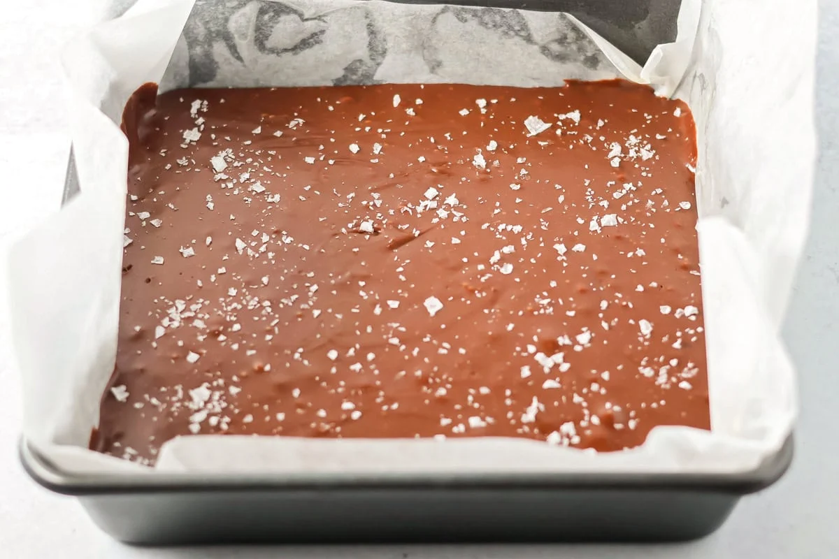Sea salt sprinkled over Nutella fudge in a pan.