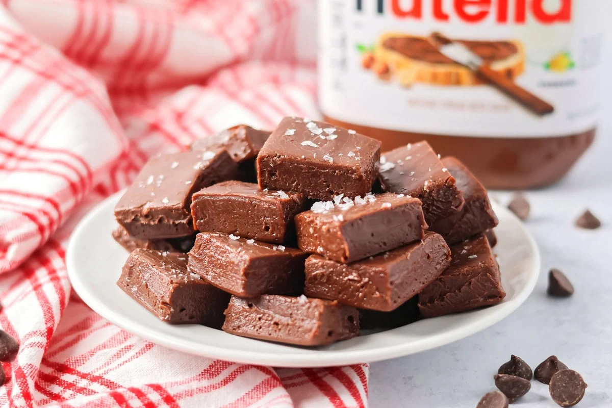 Several squares on Nutella fudge stacked on a serving plate.