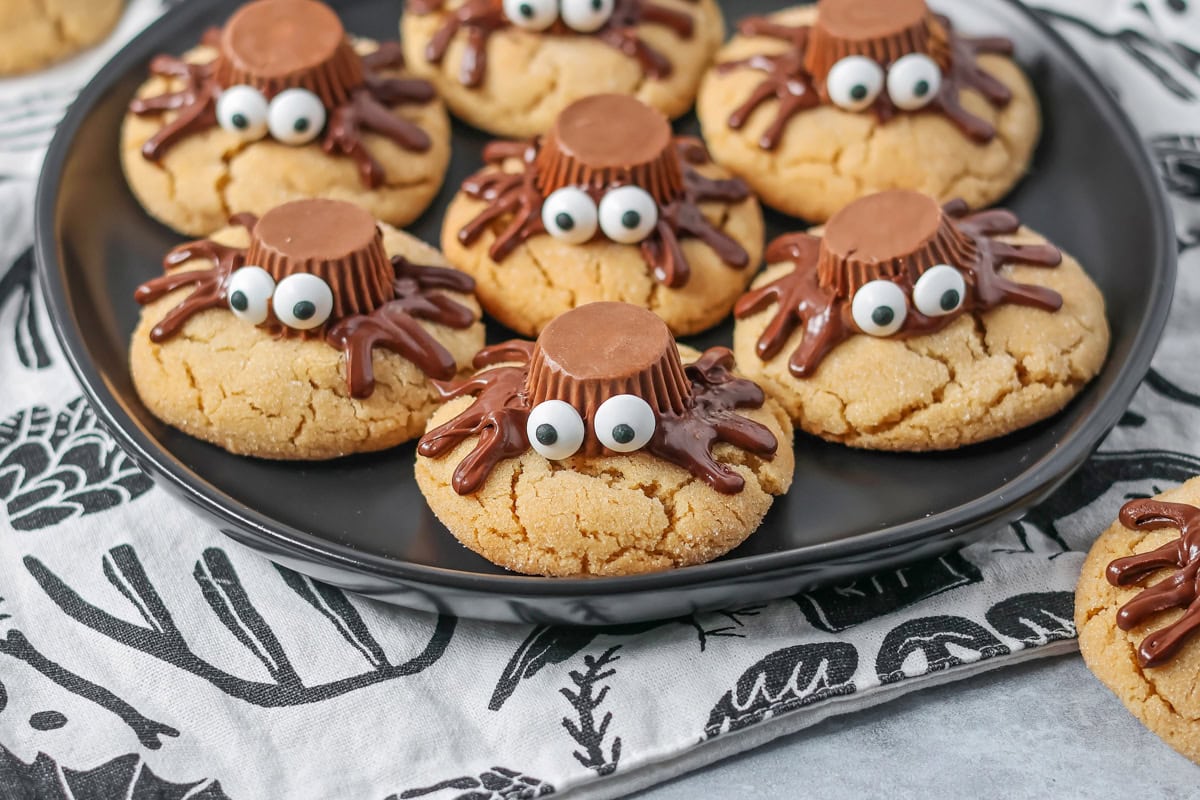 These easy and cute Peanut Butter Spider Cookies are the perfect sweet treat to get you in the spooky spirit. A black serving plate holding several peanut butter spider cookies.