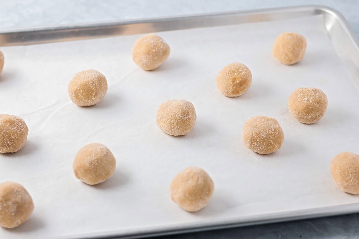These easy and cute Peanut Butter Spider Cookies are the perfect sweet treat to get you in the spooky spirit. Peanut butter cookie dough balls on a baking sheet.