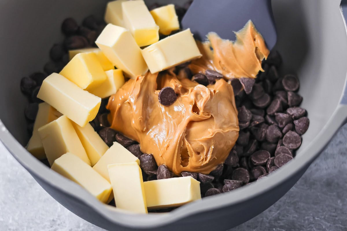 Puppy Chow Popcorn is an irresistible sweet and salty snack that's easy to make and guaranteed to be a hit. Butter, chocolate chips, and peanut butter in a saucepan.