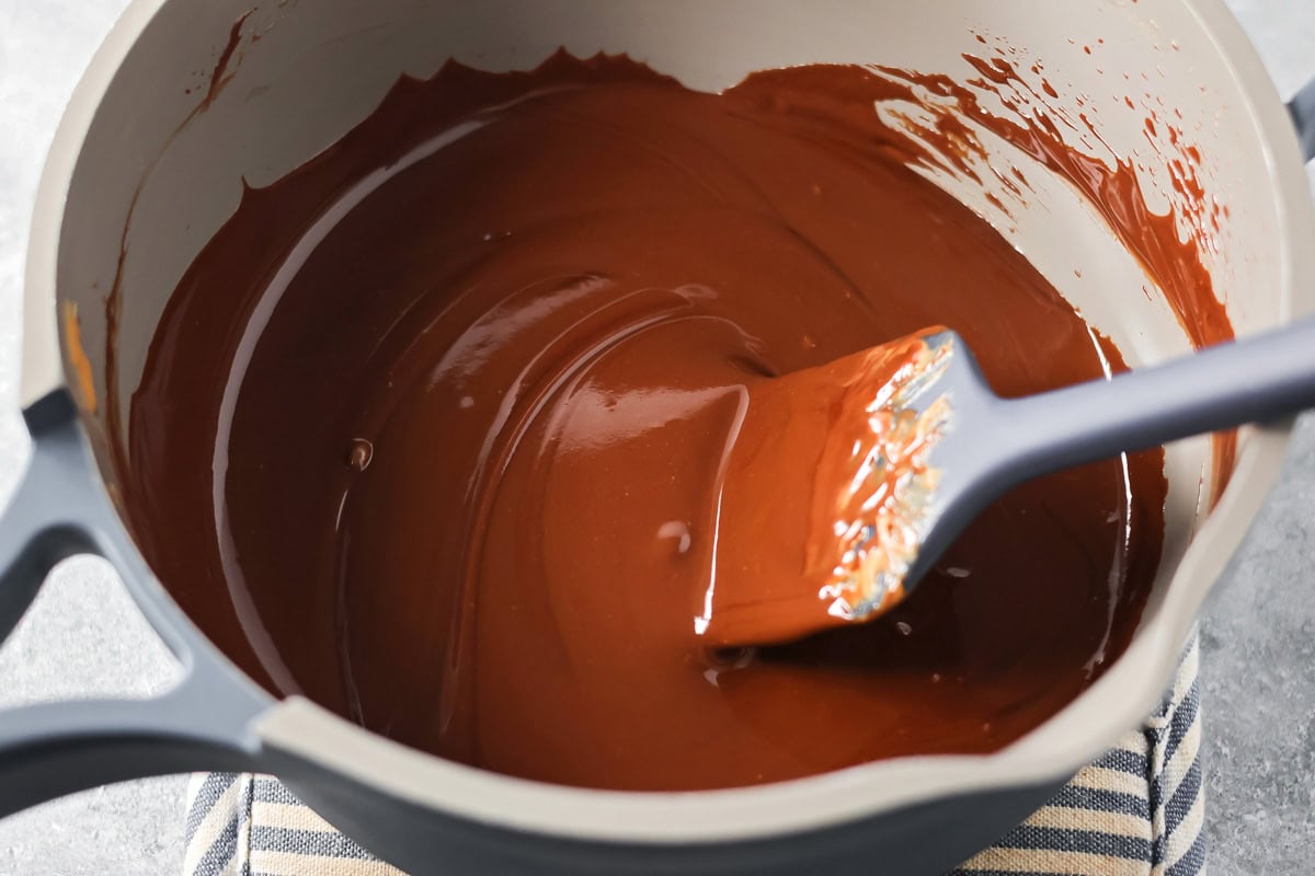 Puppy Chow Popcorn is an irresistible sweet and salty snack that's easy to make and guaranteed to be a hit. Melted peanut butter chocolate coating in a saucepan.