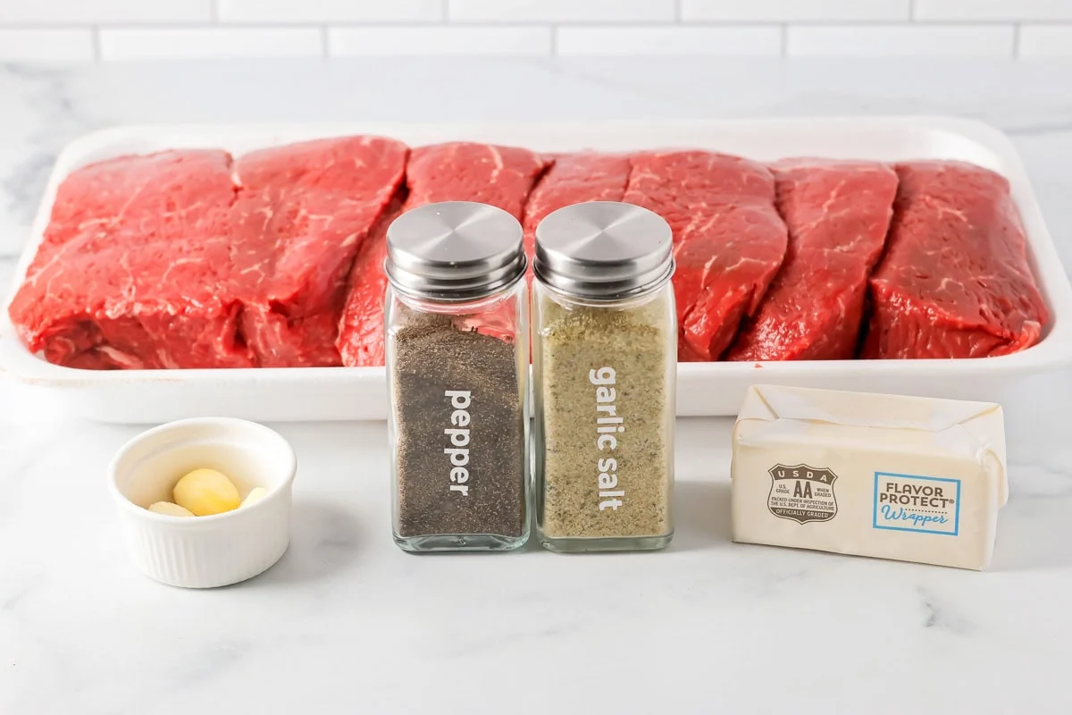 Ingredients to make grilled sirloin steak on a kitchen counter.