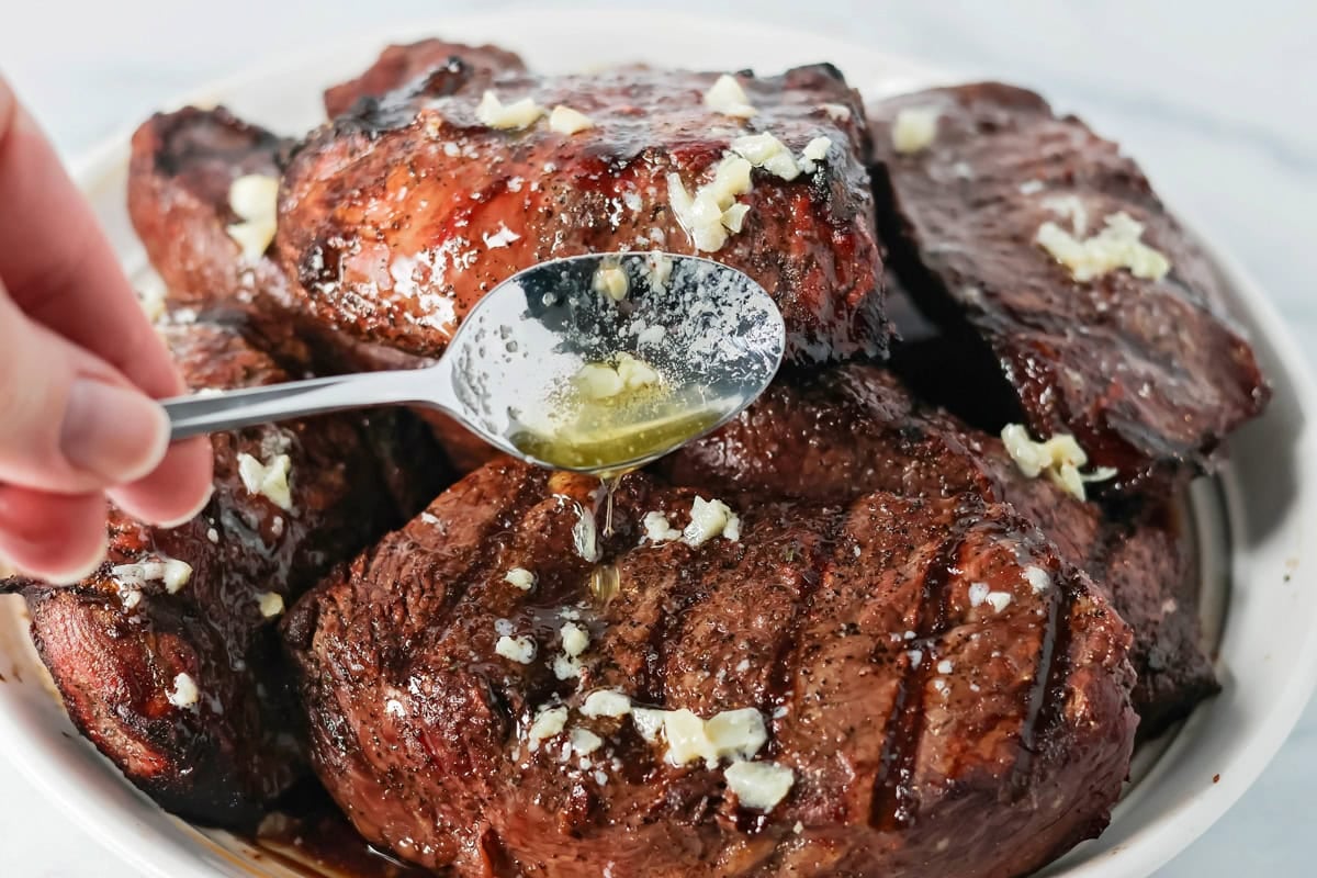 Drizzling garlic butter sauce of grilled steak.