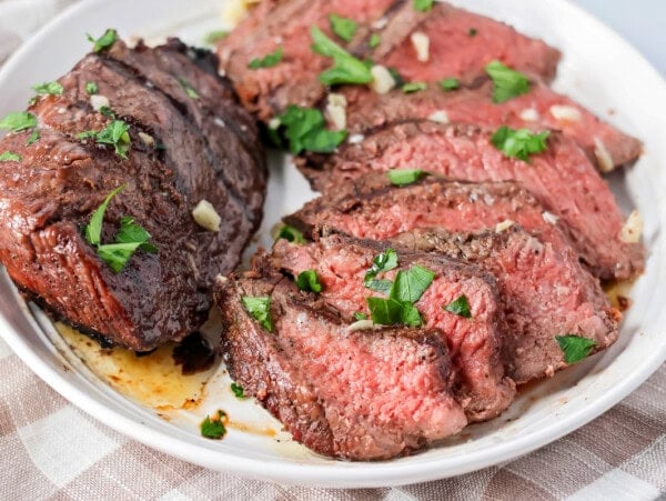 Sliced up sirloin steak served on a plate.