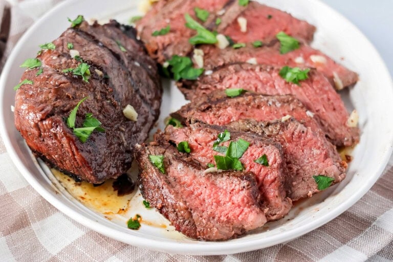 Sliced up sirloin steak served on a plate.