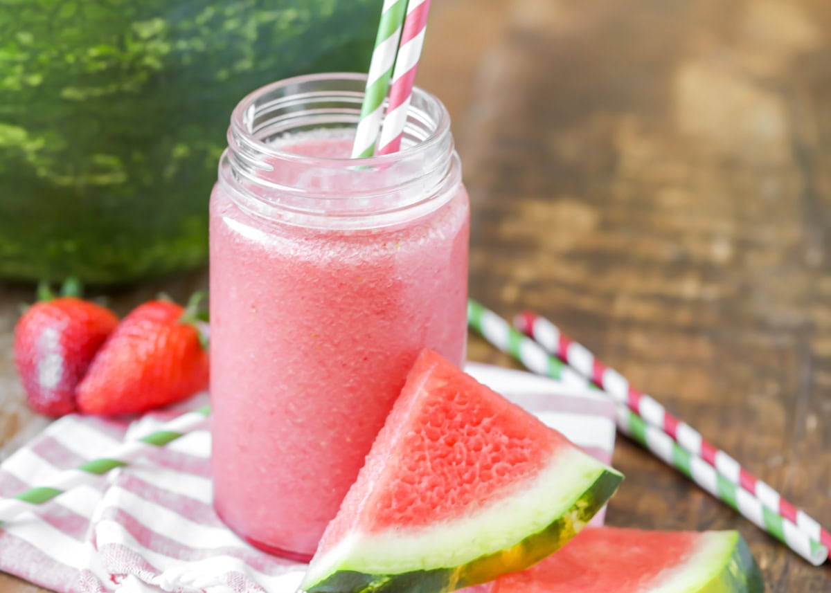 Watermelon smoothie poured into cup with straws in it.