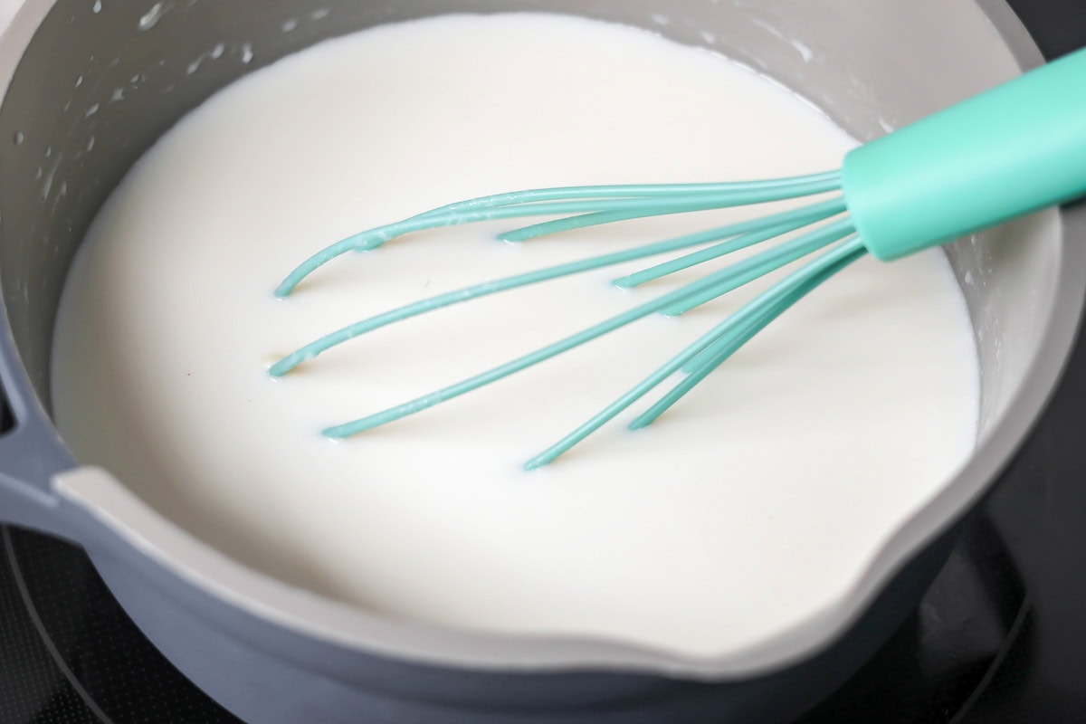 Making white chocolate hot cocoa in pot.