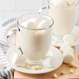 White chocolate hot cocoa in glass mug with marshmallows.