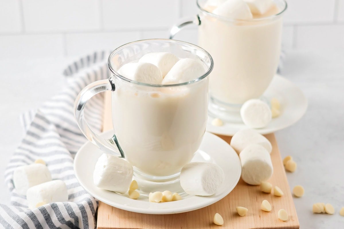 White chocolate hot cocoa in glass mug with marshmallows.